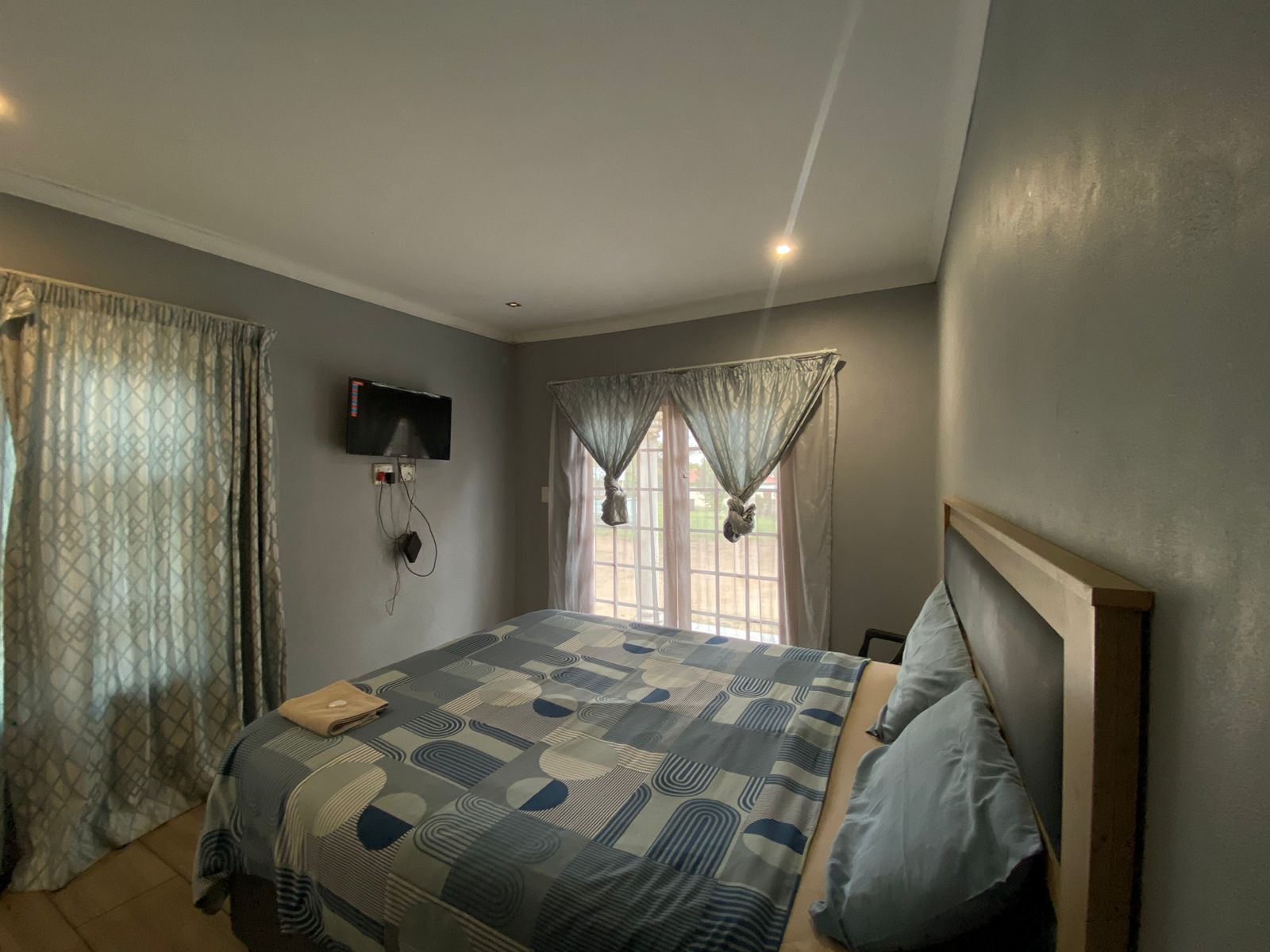 Room with light wood headboard and blue art deco circular pattern bedding