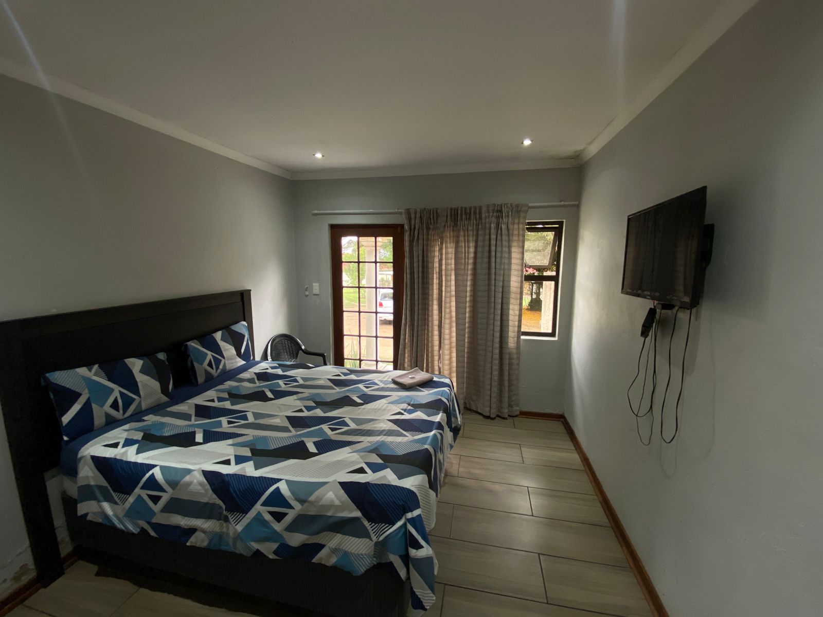 Cozy room with black headboard and geometric triangle pattern bedding